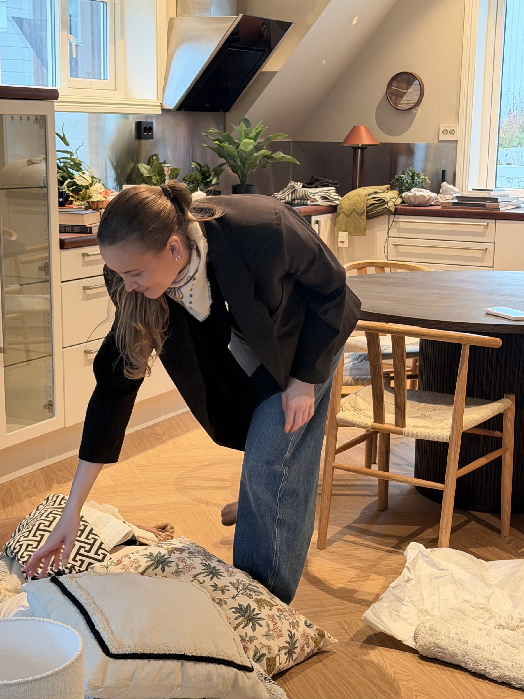 Jenny Tunelv Pedersen under styling: puter legges ut på gulvet i et kjøkken og en spisestue